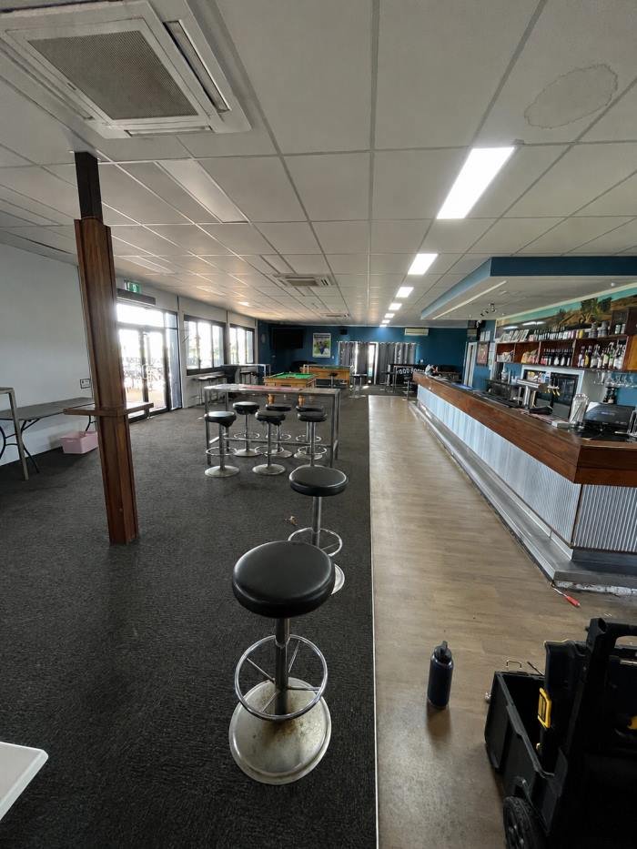 Before: old carpet tile and worn flooring in the venue